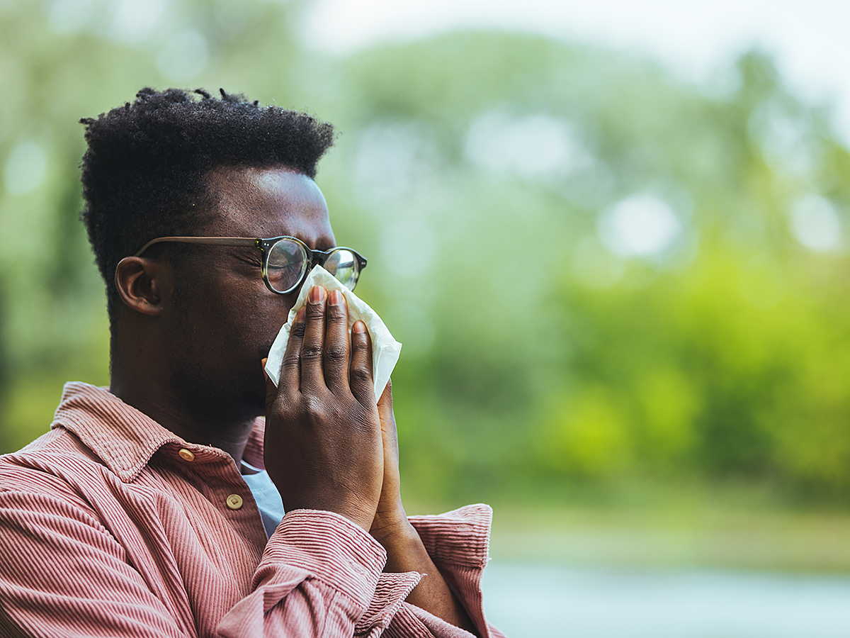 man with allergies sneezing